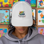 An art teacher wears a white trucker baseball hat that says "Art Teachers ... Making School Beautiful Since Forever"