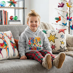 A toddler wears a gray hoodie with a festive design and the words "Little Artist for Peace"