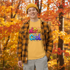 A happy art teacher wears a Warm and Cool fun tshirt in a fall outdoor scene with foliage