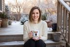 Woman holding steaming 15oz Mistakes = Growth mug on winter porch